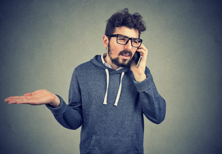 Home frustrat parlant per telèfon amb l'asseguradora