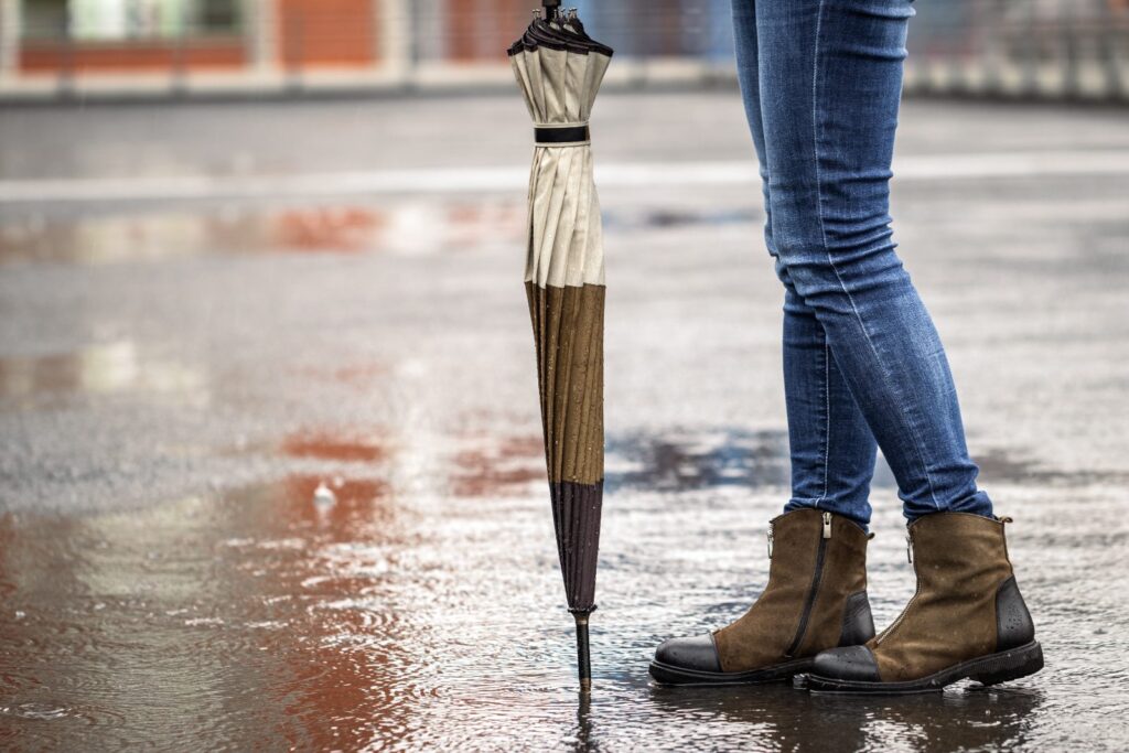Dona amb paraigua sota una pluja intensa al carrer